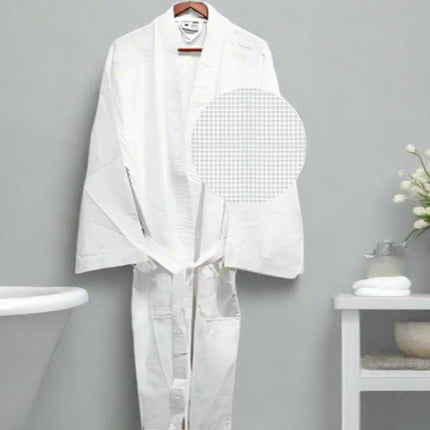 a nice white bathrobe hanging on a bathroom wall