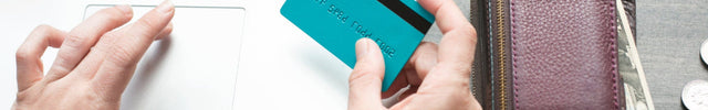 A Credit Card on the Hands and a Laptop Behind