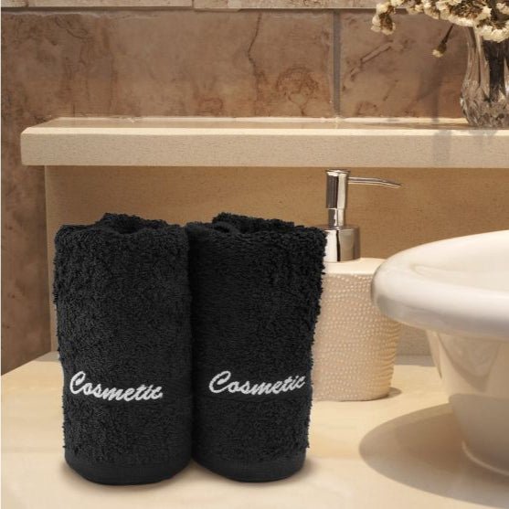 a couple of cosmetic black towels in a hotel batheroom