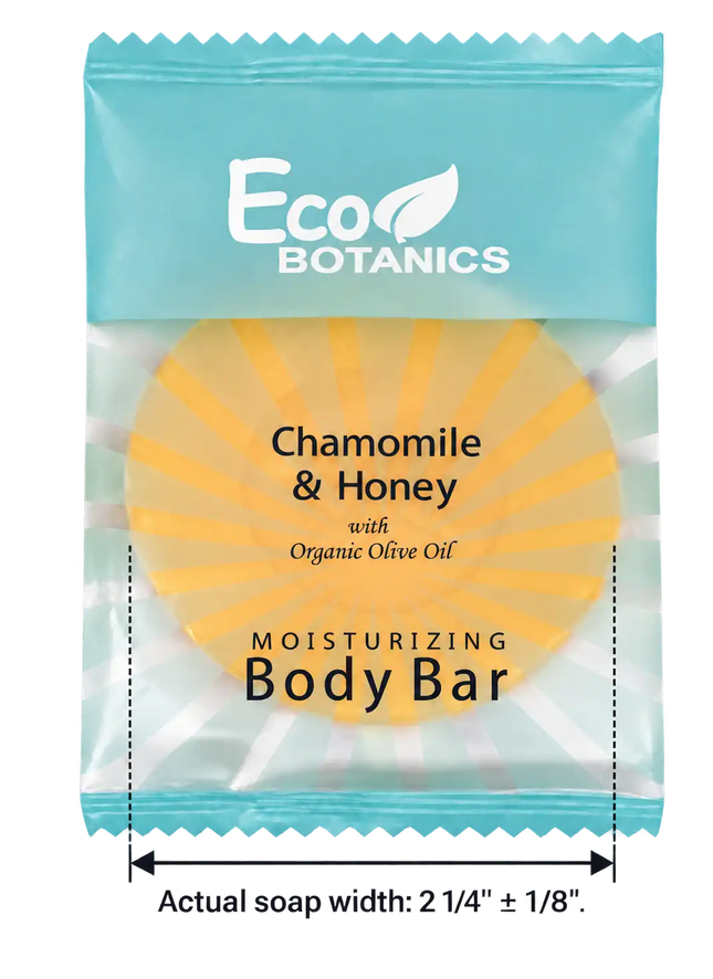 Eco Botanics Chamomile & Honey moisturizing body bar in its retail packaging, featuring a light blue wrapper with a yellow circular graphic of the soap bar inside. A dimension label at the bottom indicates the actual soap width is 2 1/4" +/- 1/8".