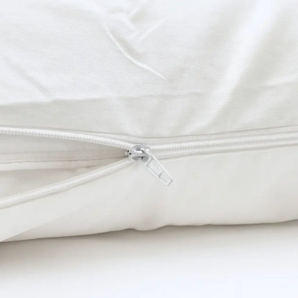 Close-up of a white quilt with a zipper on a white background
