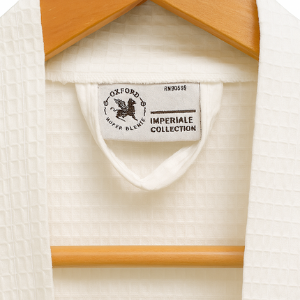 Close-up of a white shirt with a label on a wooden hanger