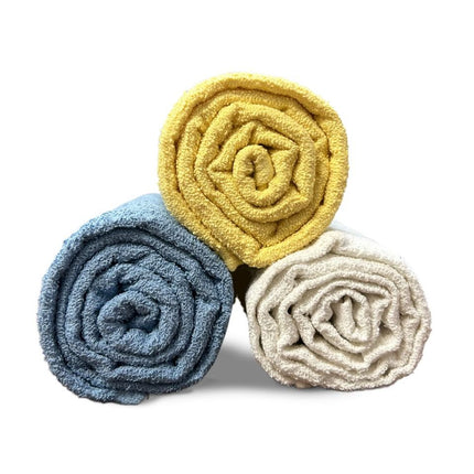 Three rolled Basic Solid Pool Towels in blue, yellow, and white, perfect for budget-conscious poolside comfort.